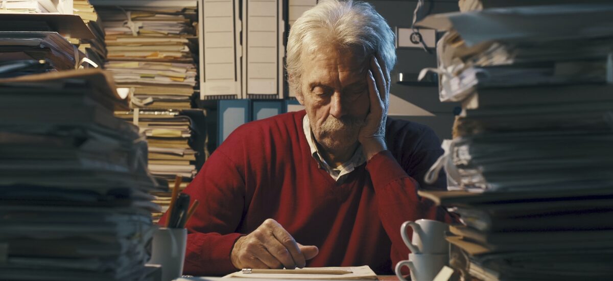 Exhausted senior office worker sleeping on the desk