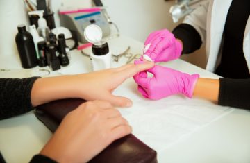 Manicure specialist prepares hands.